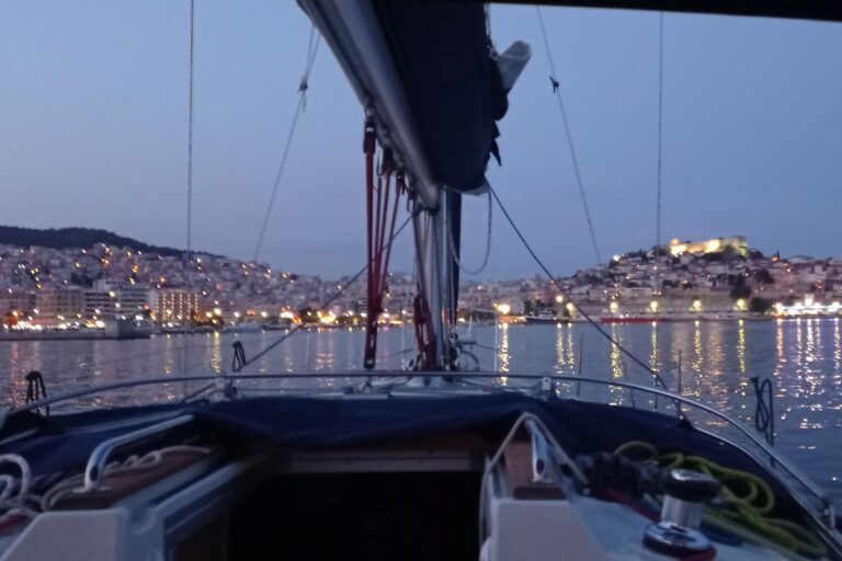 Kavala lighting up at dusk, from the bow